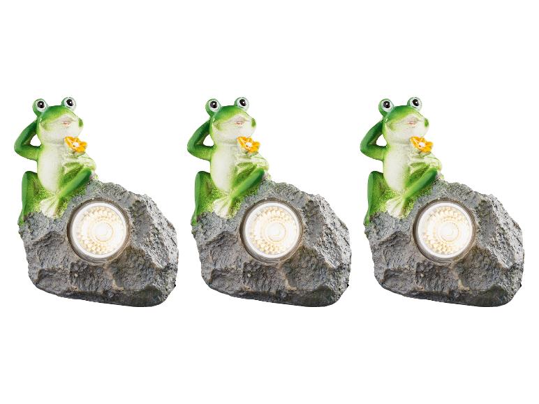 Drie kikker-vormige solar lampjes op een rots.