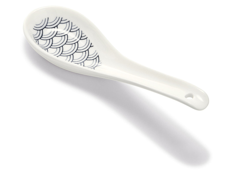 Een witte porseleinen soeplepel met een Japans design.