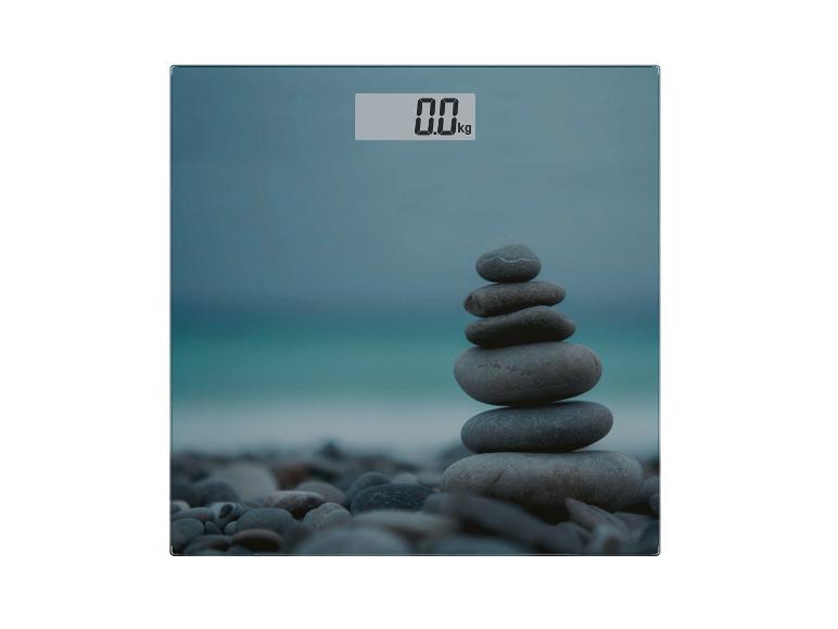 Digitale badkamerweegschaal met 0.0 kg display en gestapelde stenen op het strand.