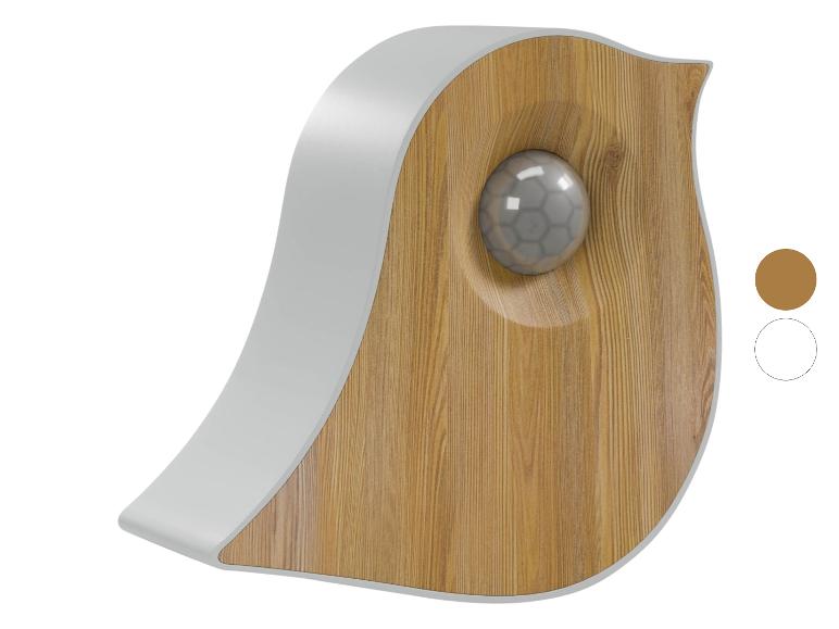 Licht houten vogelvormige wanddecoratie met een grijze rand en een grijze bol in het midden.