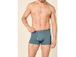 Man poseert in grijze boxershorts met blauwe tailleband.