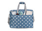 Een blauwe tas met witte stippen en handvaten, gevuld met naai-accessoires.