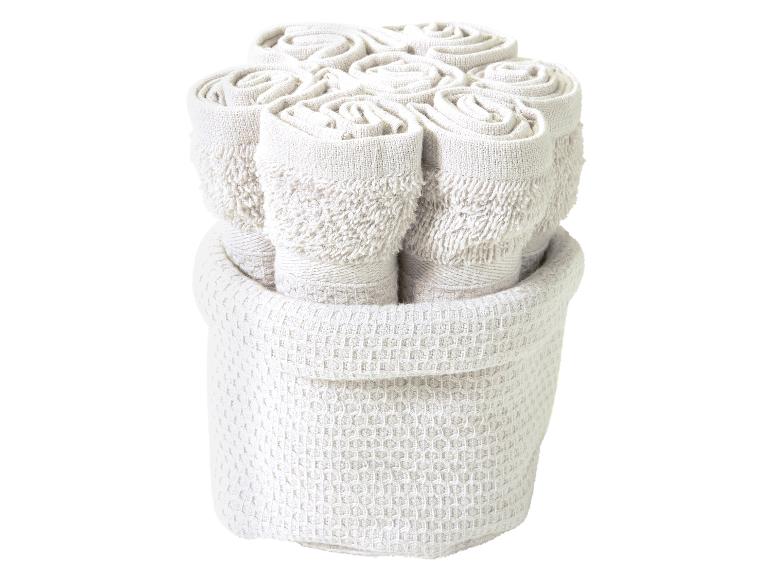 Een stapel badhanddoeken in een mand.