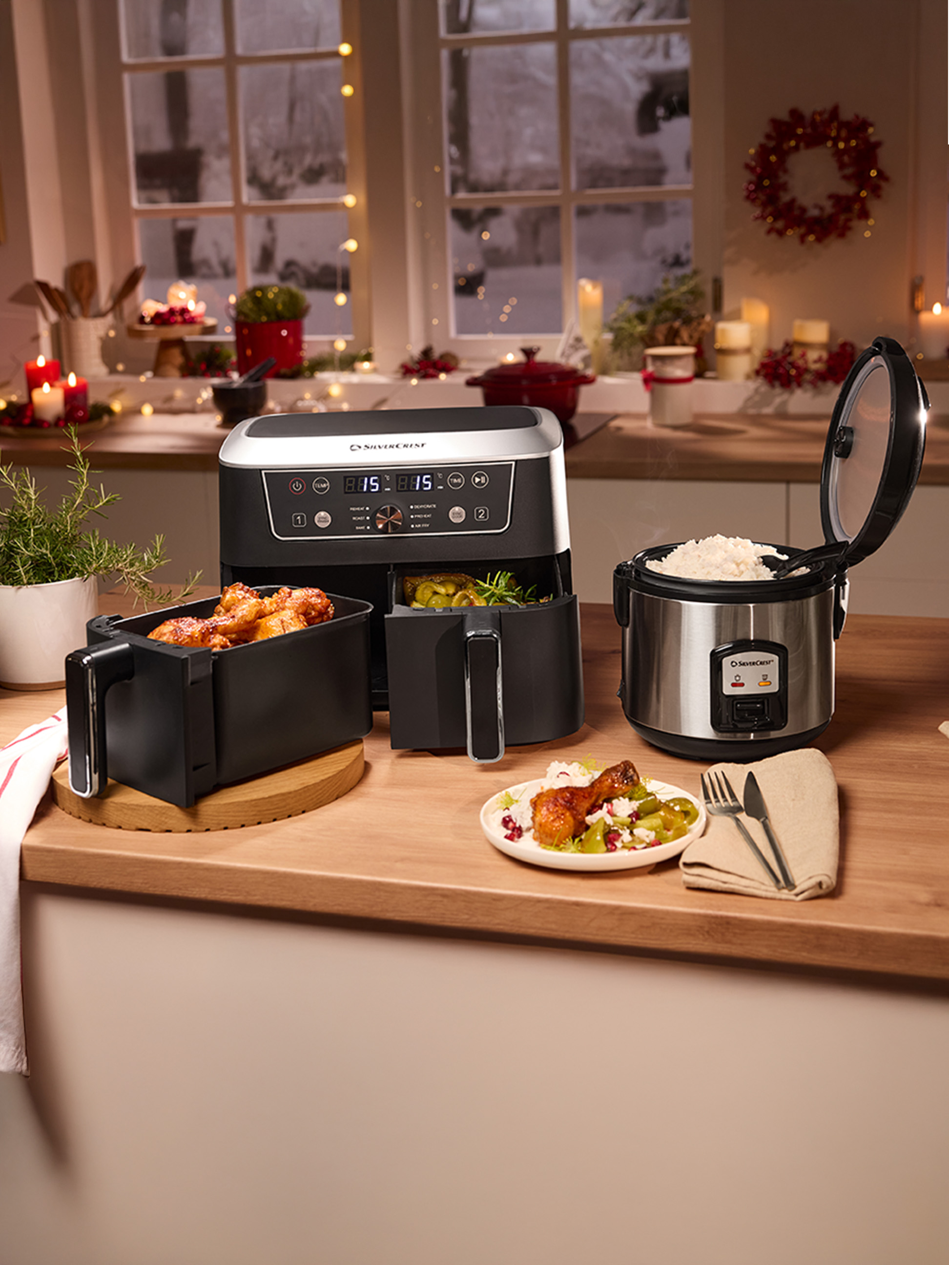 Silvercrest airfryer en rijstkoker op een aanrecht, met gekookt eten en feestelijke decoraties.