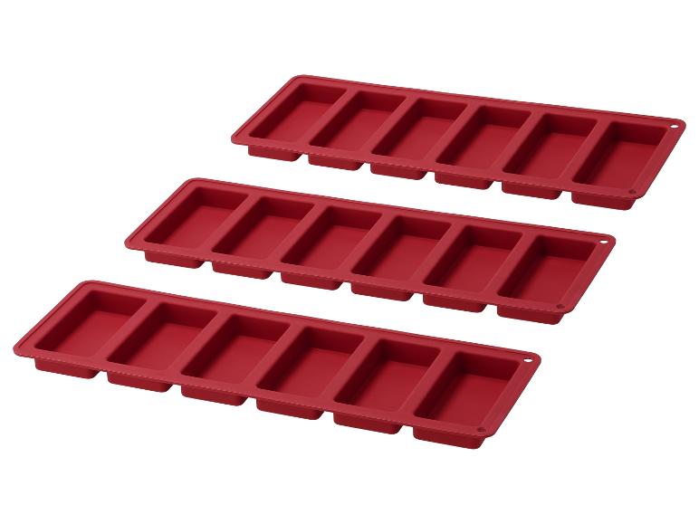 Drie rode siliconen vormen om chocolade repen of zeep te maken.