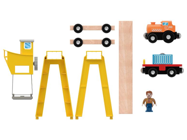 Houten speelgoed, waaronder een kraan, treinrails, wagons en een figuur.