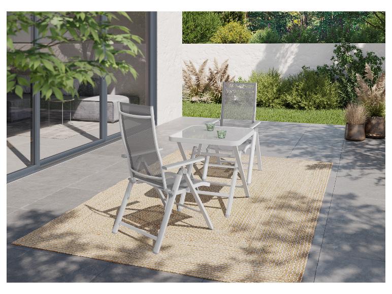 Buiten eethoek met twee klapstoelen en een tafel op een terras met een vloerkleed.