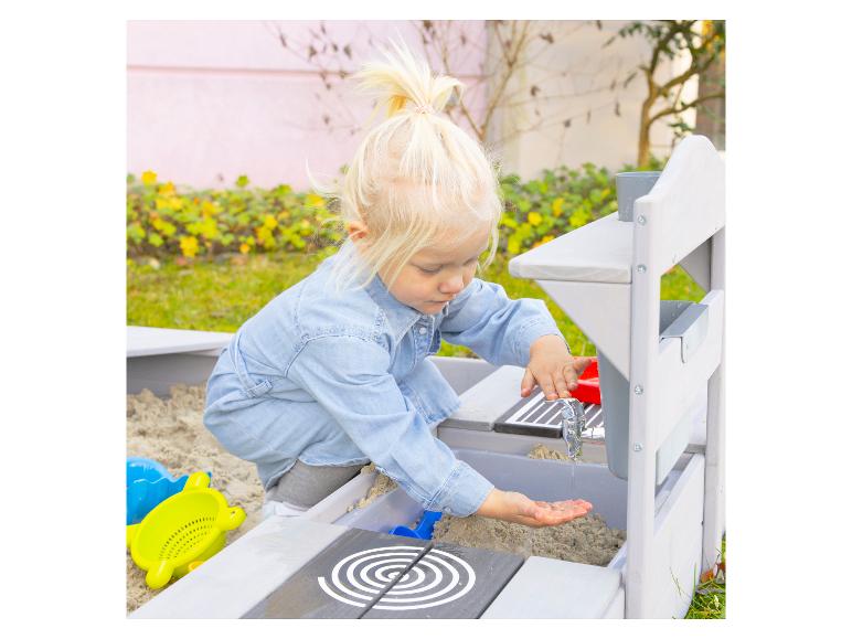 Kind speelt met een houten modderkeuken met zand en water