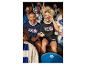 Man en vrouw in NFL-shirts zitten in een stadion met andere fans.