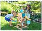 Twee kinderen spelen met een houten watermolen en emmers in de tuin.