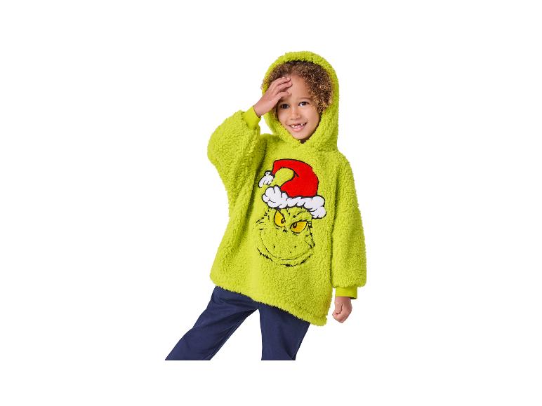 Jongen in een groene Grinch-hoodie en donkerblauwe broek.