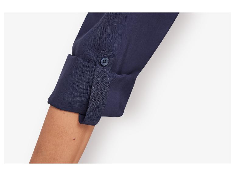 Detail van een donkerblauwe blouse met lange mouwen.