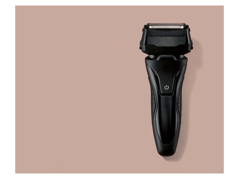 Zwart elektrisch scheerapparaat op een roze-beige achtergrond.