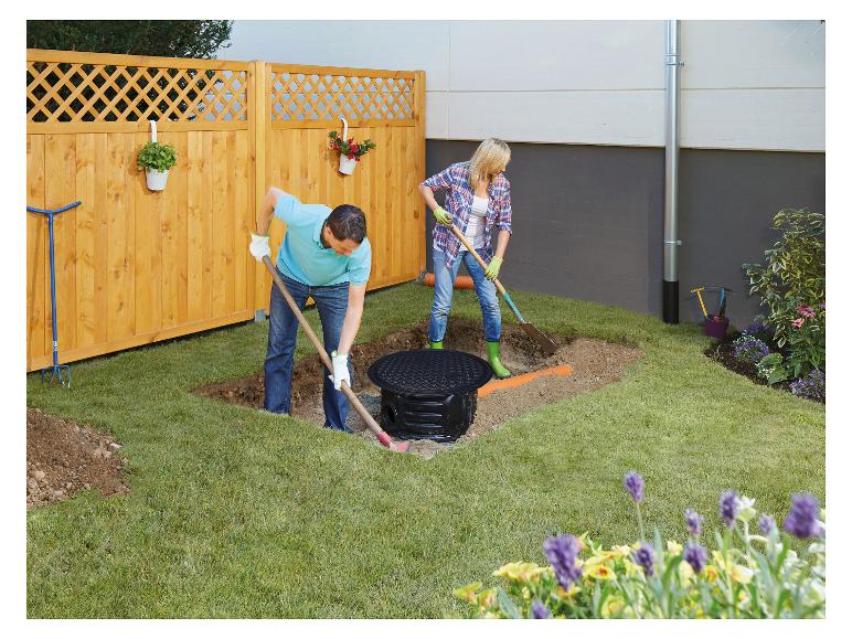 Een koppel installeert de 4RAIN COMPACT ondergrondse regenwatertank in de tuin.