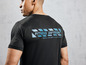 Een man draagt een zwart T-shirt met 'Fitness Division' erop.