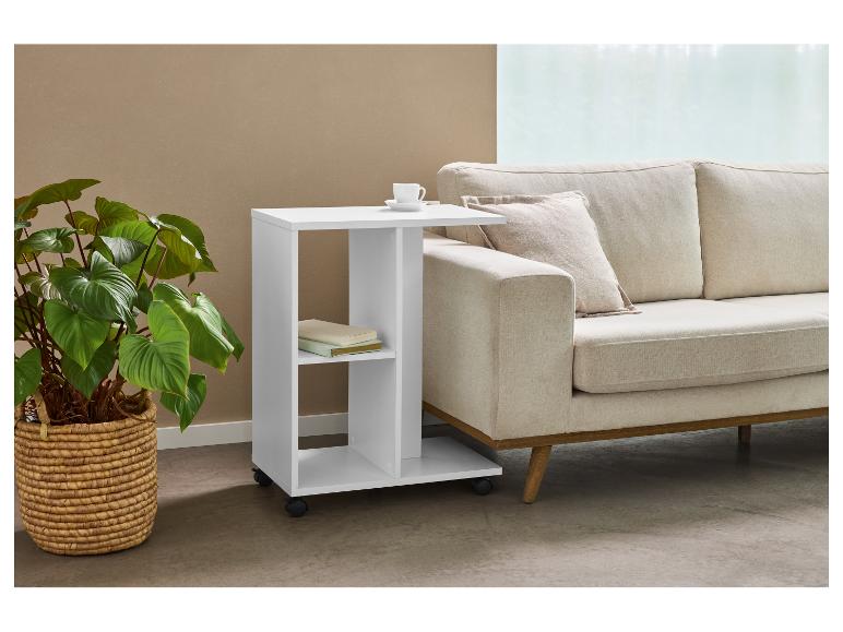 Witte bijzettafel op wielen naast een beige bank en kamerplant.