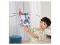Een jongen speelt met een witte speelgoedhelikopter met een rode staart en blauwe details.