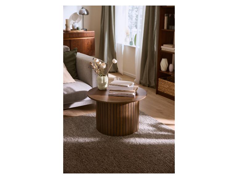 Ronde houten salontafel met boeken en vaas in de woonkamer.