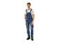 Man in blauwe denim tuinbroek en wit T-shirt, met de hand in de zak.