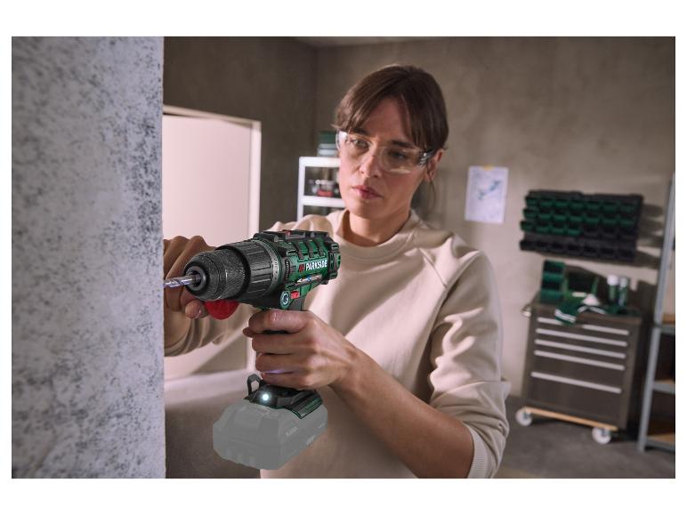 Vrouw met veiligheidsbril gebruikt een PARKSIDE accuboormachine om in een muur te boren.