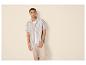 Man in gestreept overhemd en beige broek.