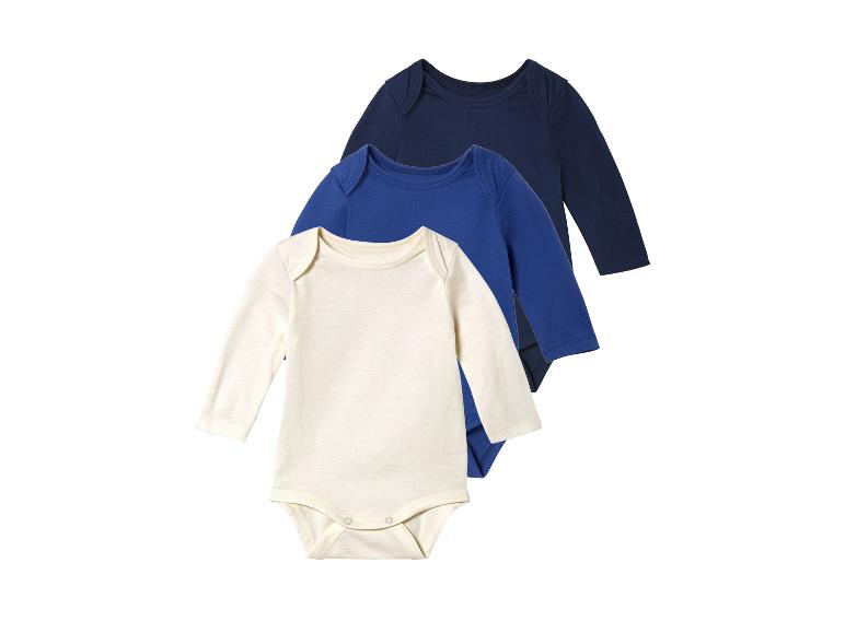 Drie baby-rompers met lange mouwen in donkerblauw, lichtblauw en crème.