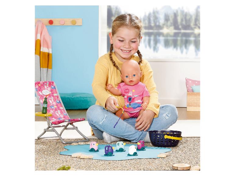 Meisje speelt met een pop en een visspel met kleurrijke pinguïns.