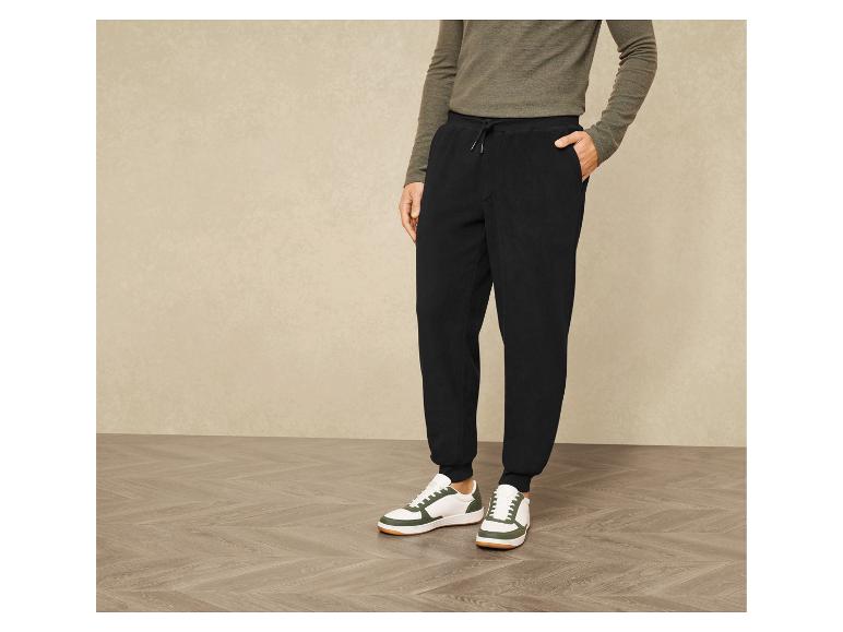 Zwarte joggingbroek met witte sneakers.