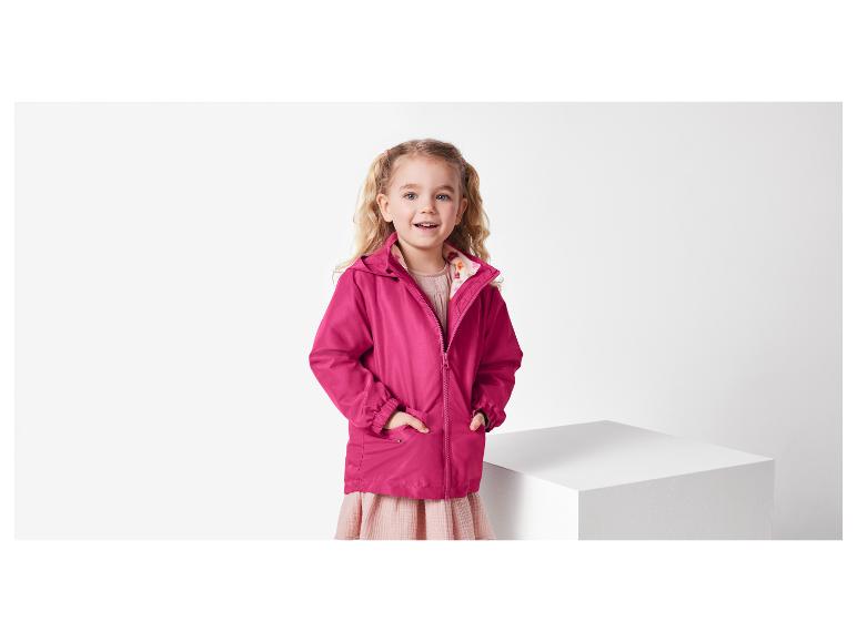 Een meisje in een roze jas met capuchon.