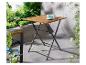 Houten klaptafel op balkon met kopje en aardbei, omringd door groen.
