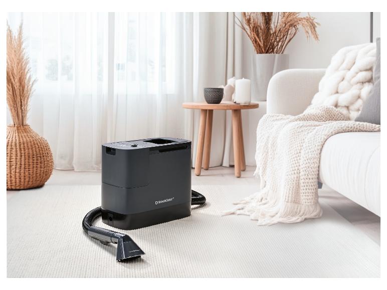 SilverCrest tapijtreiniger in een woonkamer met wit tapijt en bank.