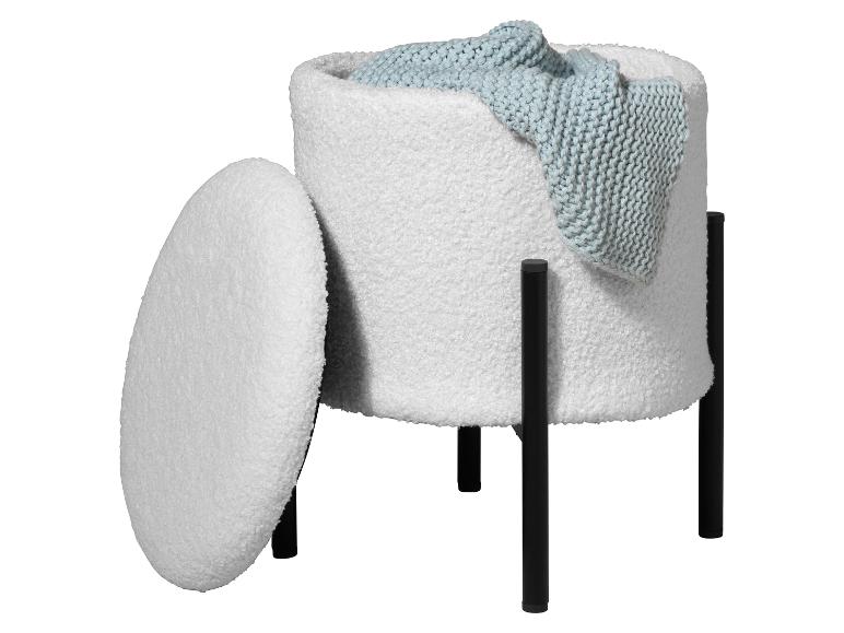 Witte, getextureerde opbergpoef met deksel en zwarte poten, met een blauw gebreid deken erin.