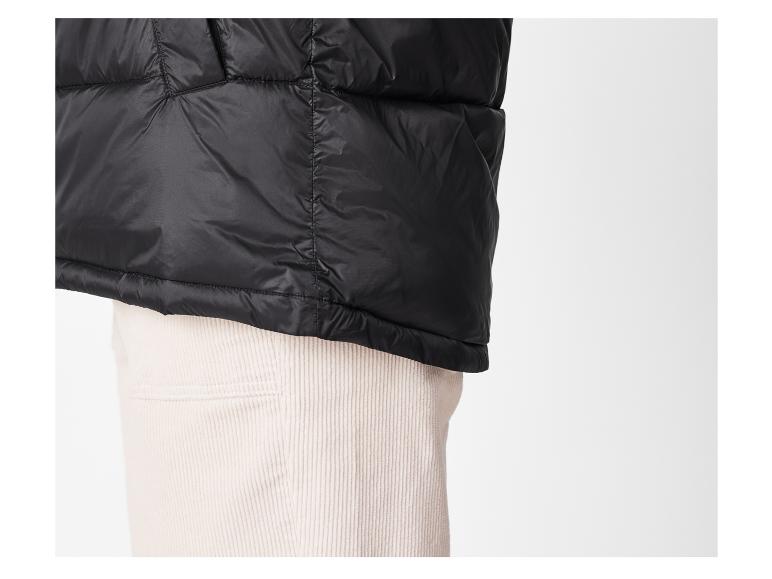 Zwarte pufferjas over corduroybroek.