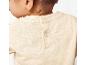 Beige baby shirt van lichte stof, met drukknoopjes op de rug.