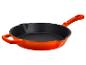 Oranje gietijzeren koekenpan met zwarte binnenkant en lange steel.