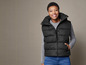 Een vrouw draagt een zwarte puffer vest.