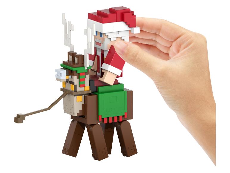 Een Minecraft kerstmanfiguur op een rendier, vastgehouden door een hand.