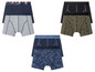 Drie paar boxershorts met verschillende prints, waaronder een met palmbomen.