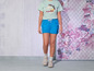 Een vrouw draagt een lichtgroen T-shirt met de tekst 'Pink Island Paradise' en blauwe shorts.