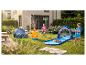 Kinderen spelen in de tuin met een opblaasbare zeestersproeier en een haaienwaterglijbaan.