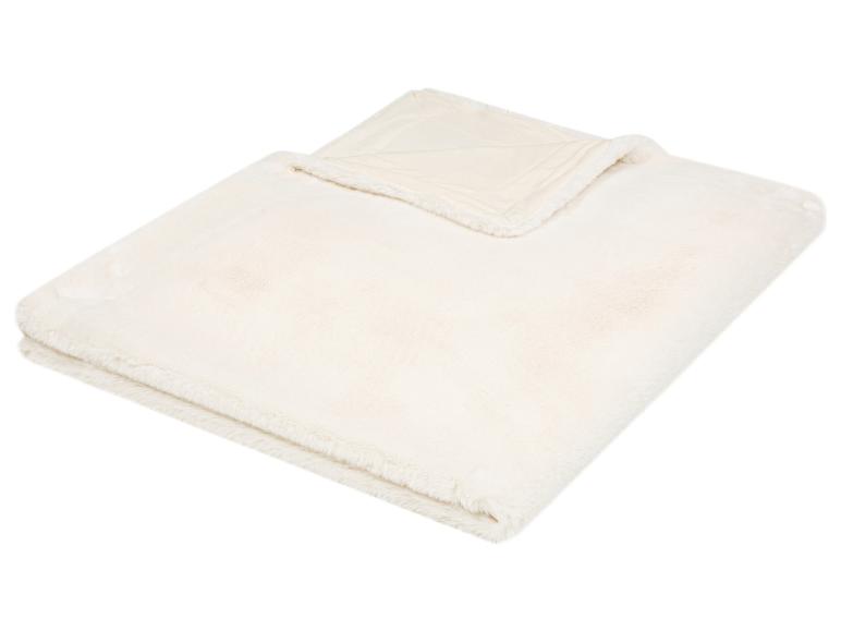 Crèmekleurige, pluizige imitatiebont deken, opgevouwen op een witte achtergrond.