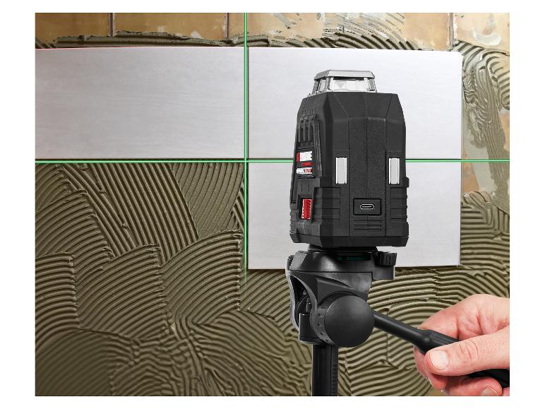 Kruislijnlaser op statief, projecteert groene lijnen op wandtegels met lijm.