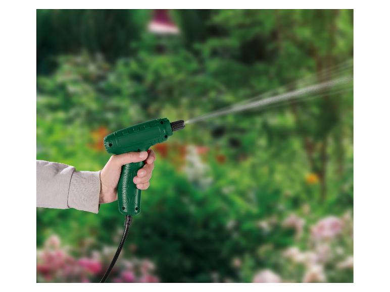 Handbediend groen spuitpistool dat water spuit in een groene tuin.