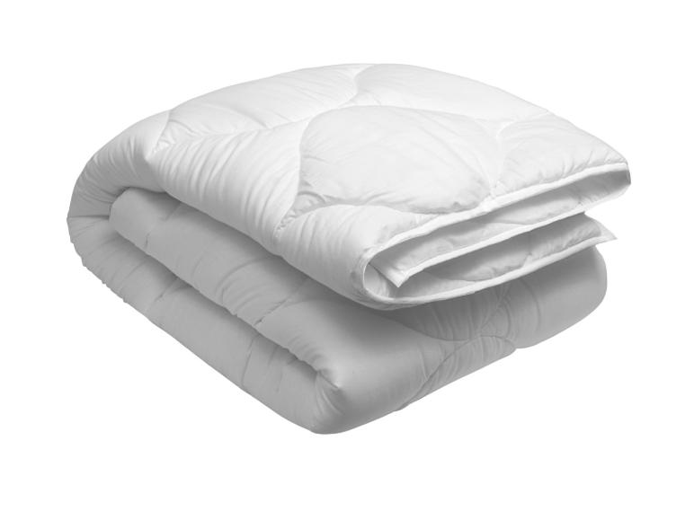 Opgevouwen wit dekbed of sprei met een gewatteerd patroon