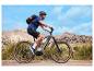 Fietser op een elektrische mountainbike met rugzak en helm in bergachtig landschap.