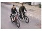 Koppel op elektrische fietsen op een stadsweg.