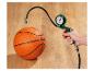 Hand houdt een groene luchtdrukmeter vast, aangesloten op een oranje basketbal.