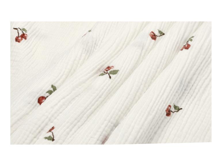 Witte mousseline stof met geborduurde rode kersen en groene blaadjes.