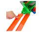 Hand drukt op een oranje speelgoedbaan met een groene en grijze speelgoedstructuur op de achtergrond.