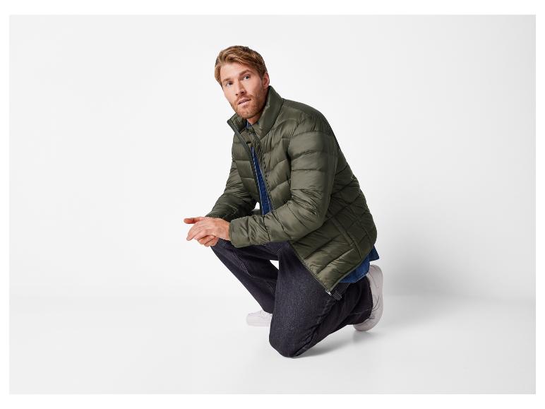 Man in een groene jas en jeans.